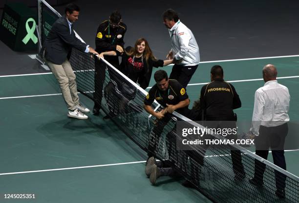 Security staff members detain environmental group Futuro Vegetal's activists protesting during the men's single quarter-final tennis match between...