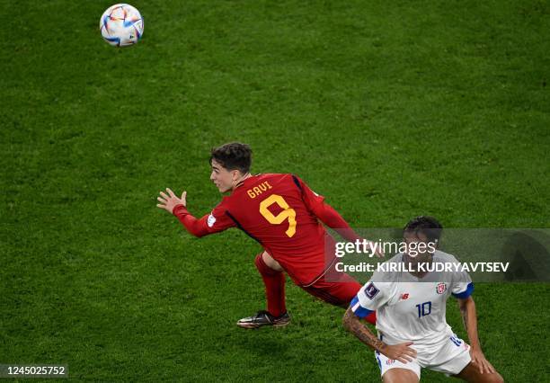 Spain's midfielder Gavi and Costa Rica's midfielder Bryan Ruiz eye the ball during the Qatar 2022 World Cup Group E football match between Spain and...