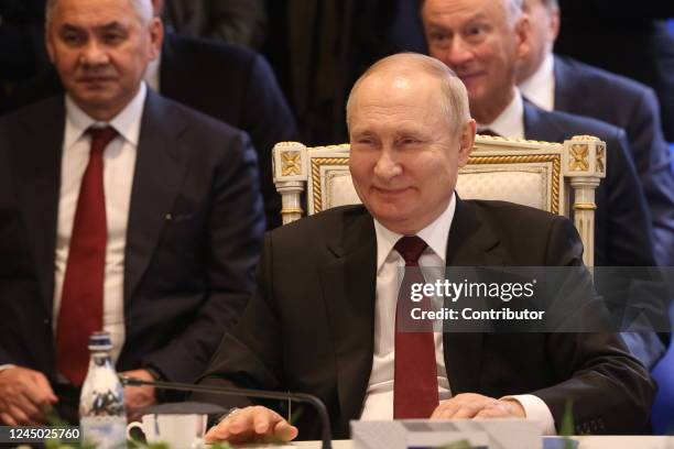 Russian President Vladimir Putin smiles as Defense Minister Sergei Shoigu and Security Council Secretary Nikolay Patrushev look on during the SCTO...