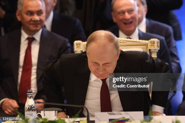 Russian President Vladimir Putin smiles as Defense Minister Sergei Shoigu and Security Council Secretary Nikolay Patrushev look on during the SCTO...