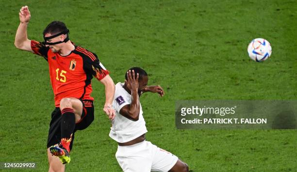 Belgium's defender Thomas Meunier and Canada's forward Junior Hoilett clash heads during the Qatar 2022 World Cup Group F football match between...