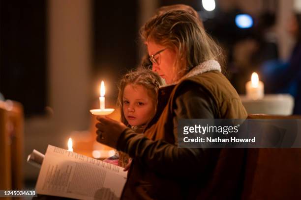 Harley Marshall and her mother Devan Marshall listen to prayer during a vigil at St. Thomas Episcopal Church for those killed in a fatal shooting at...