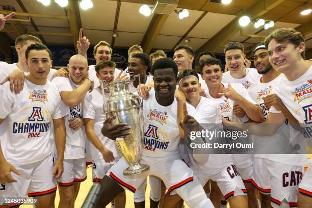 Oumar Ballo of the Arizona Wildcats holds the championship trophy and poses for a photo with his team after winning the championship game of the Maui...