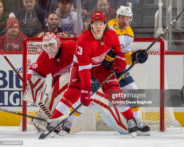 Ville Husso of the Detroit Red Wings watches the play as teammate Moritz Seider battles with Cole Smith of the Nashville Predators in front of the...