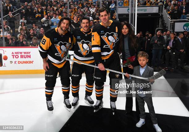 Evgeni Malkin family pose with a stick honoring his 1000th NHL game Kris Letang and Sidney Crosby of the Pittsburgh Penguins prior to the game...