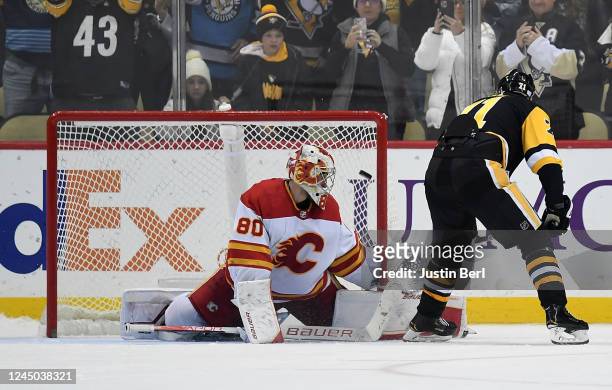 Evgeni Malkin of the Pittsburgh Penguins scores the game winning goal in a shootout past Dan Vladar of the Calgary Flames to give the Penguins a 2-1...