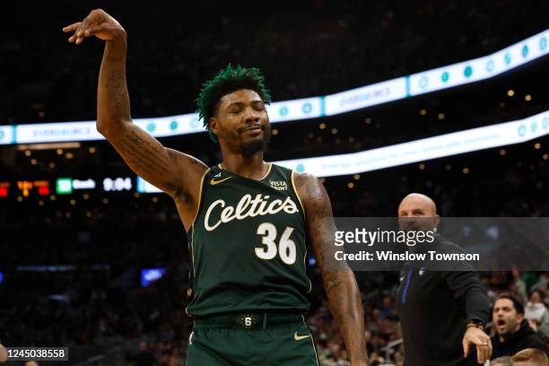 Marcus Smart of the Boston Celtics smiles at the Dallas Mavericks bench after hitting a three point shot as Dallas head coach Jason Kidd looks on...