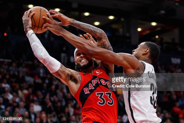 Nic Claxton of the Brooklyn Nets and Gary Trent Jr. #33 of the Toronto Raptors battle for the ball during the second half of their NBA game at...