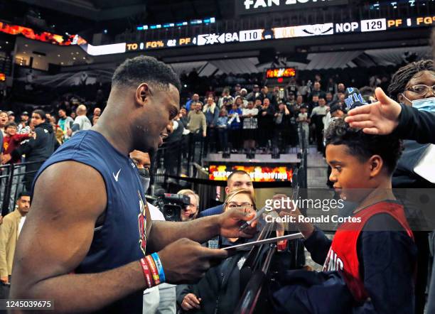 Zion Williamson of the New Orleans Pelicans took time to sing autographs at the end of the game against the San Antonio Spurs at AT&T Center on...