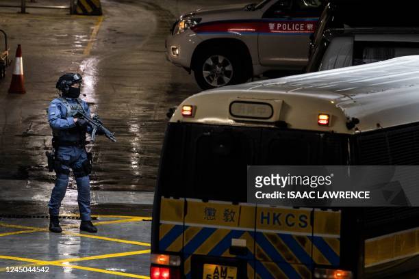 An armed police officer stands guard after Jimmy Lai arrives in a correctional services van at the district court in Hong Kong on November 24 for...