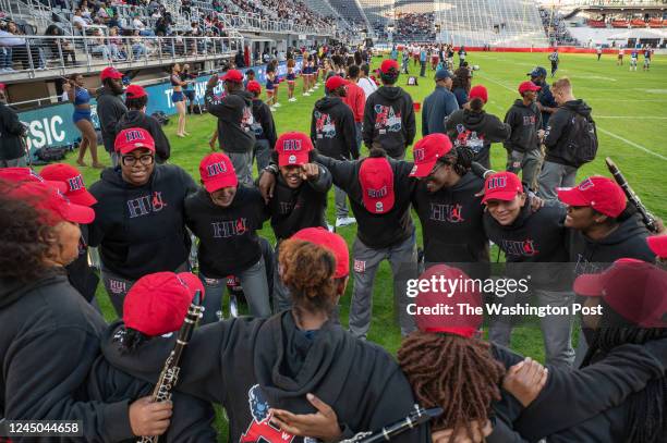 Howard University band members hype each other up before performing at halftime during the Howard-Harvard University football game at Audi Field in...