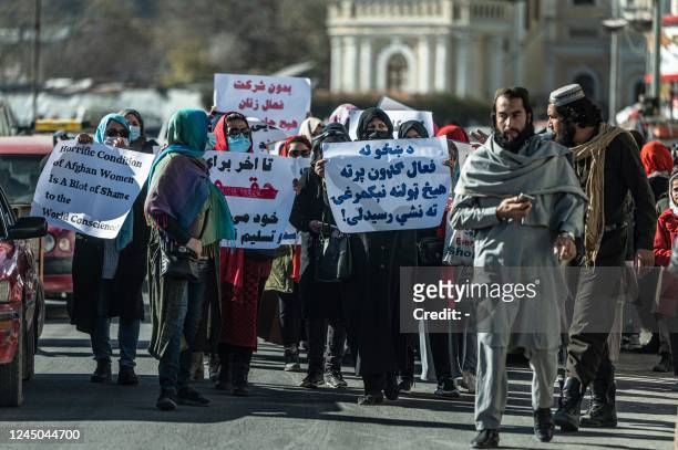 Women hold placards during a protest calling for their rights to be recognised, near the Shah-e-Do Shamshira mosque in Kabul on November 24, 2022. -...