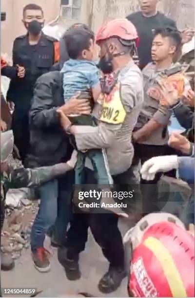 Screen grab captured from a video shows a search and rescue team member holding the boy who was pulled from rubble two days after 5.6 magnitude...