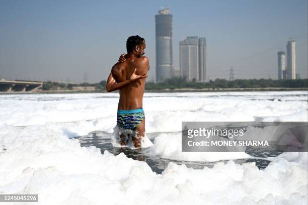 Man bathes in the polluted Yamuna River in New Delhi on November 24, 2022.