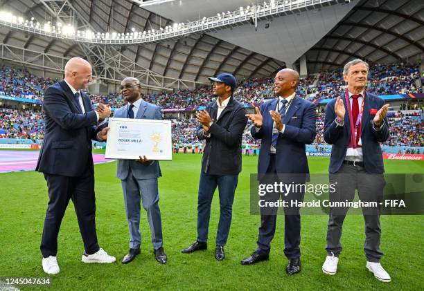President Gianni Infantino presents award to FIFA Legend Roger Milla alongside Cameroonian Football Federation President Samuel Eto'o, CAF President...