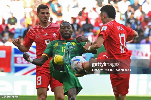 Cameroon's forward Karl Toko Ekambi fights for the ball with Switzerland's midfielder Remo Freuler and forward Ruben Vargas during the Qatar 2022...