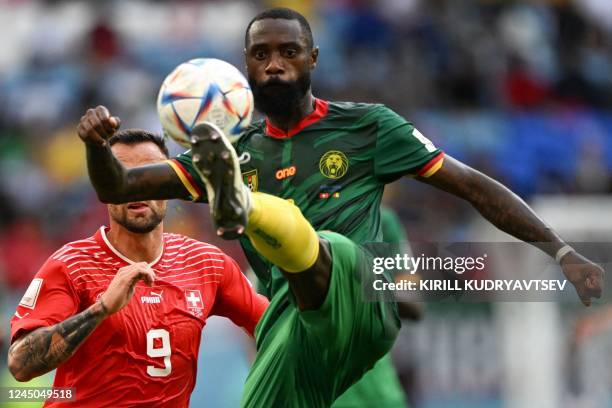 Cameroon's defender Nicolas Nkoulou kicks the ball past Switzerland's forward Haris Seferovic during the Qatar 2022 World Cup Group G football match...