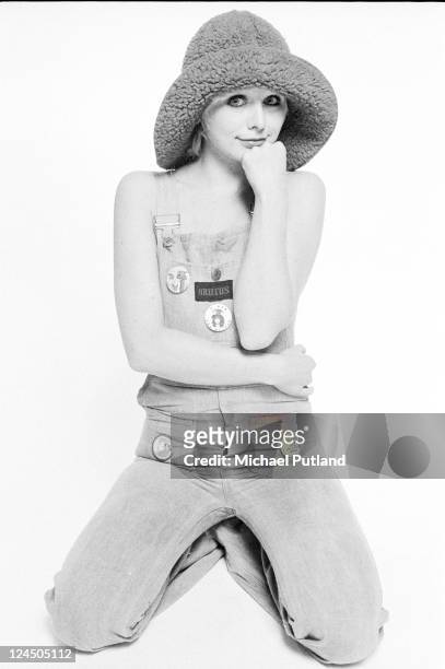 Cathy Symmonds, fashion model wearing 1970s fashions including dungarees with a Marc Bolan badge, studio, London, 1973.
