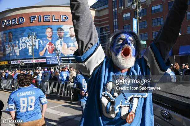 Detroit fan cheers as he walks along the sidewalk outside of Ford Field while fans wait for the doors to open before the start of a regular season...