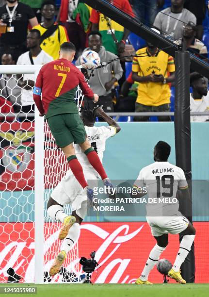 Portugal's forward Cristiano Ronaldo jumps to head the ball as Ghana's forward Inaki Williams looks on during the Qatar 2022 World Cup Group H...