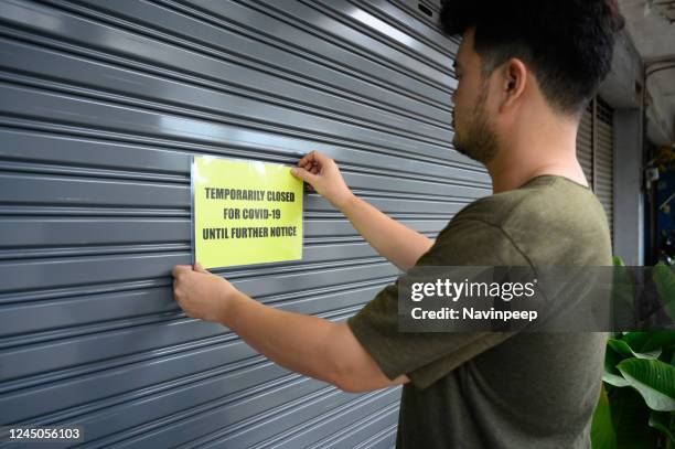 signage on door, temporarily closed for covid-19 until further notice, metal shutter - closed until further notice stock-fotos und bilder