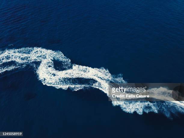 boat wake from above. high contrast abstract background. - kielwasser stock-fotos und bilder