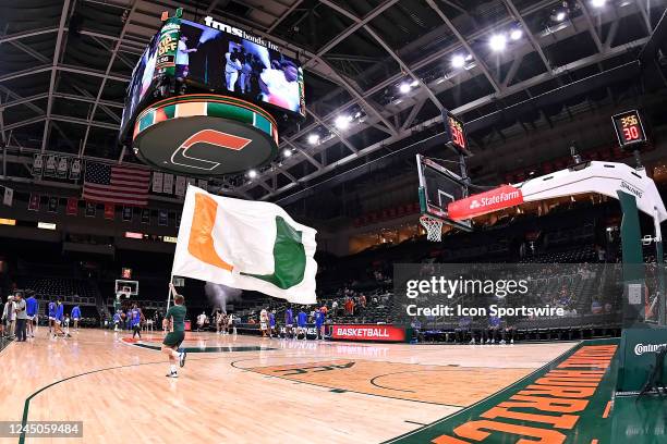 One of Miamis cheerleaders runs the U flag onto the court prior to the game as the Miami Hurricanes faced the St. Francis Terriers on November 23 at...