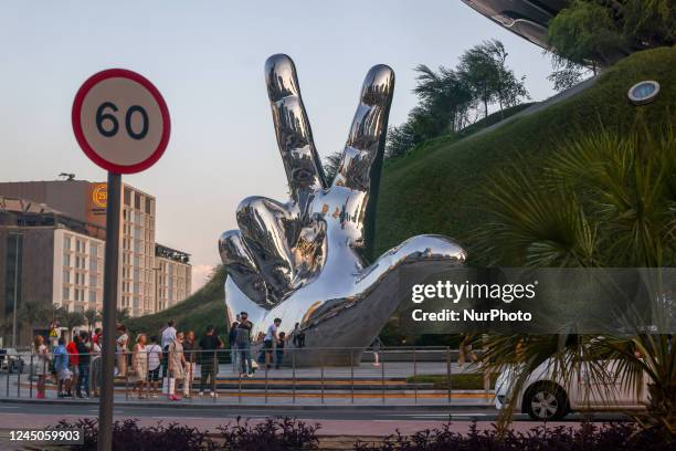 Hand Sculpture in front of a Gulf mega-museum, symbolizing human presence amid monumental architecture