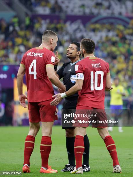 Nikola Milenkovic of Serbia is spoken to by referee Alireza Faghani with Dusan Tadic of Serbia during the FIFA World Cup Qatar 2022 Group G match...