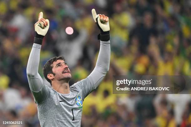 Brazil's goalkeeper Alisson celebrates after Brazil's forward Richarlison celebrates scoring their team's second goal during the Qatar 2022 World Cup...