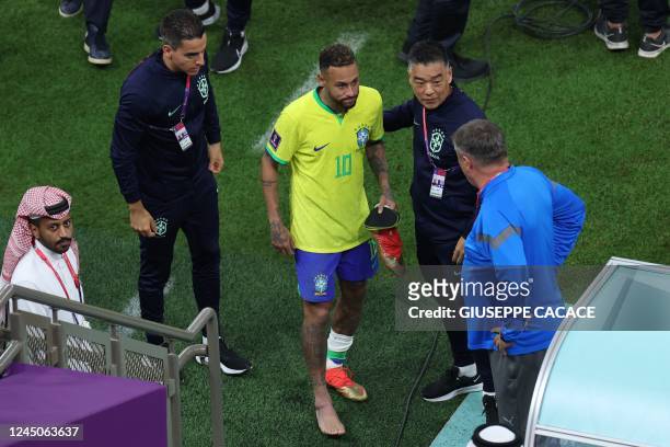 Brazil's forward Neymar walks with a swollen ankle at the end of the Qatar 2022 World Cup Group G football match between Brazil and Serbia at the...