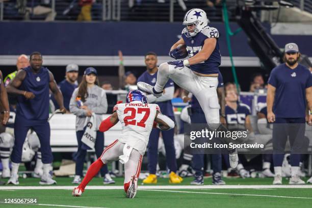 Dallas Cowboys tight end Jake Ferguson catches a pass for a first down and leaps over New York Giants cornerback Jason Pinnock during the game...