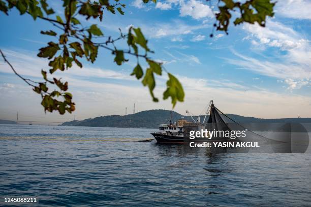 Fishing boat lays its nets in the Marmara sea off the cost of Istanbul, on November 6, 2022. - It is high season for the popular variety of tuna,...