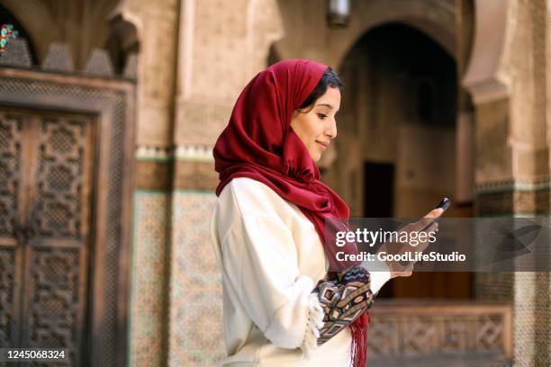 arab woman using a mobile app - middle east north africa stock pictures, royalty-free photos & images