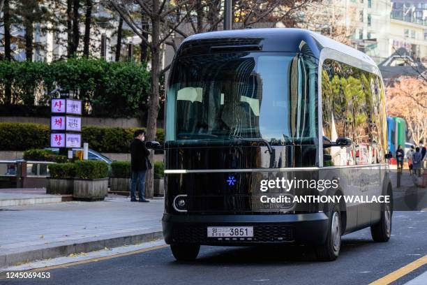 This photo taken in Seoul on November 23, 2022 shows a bus with a blue coloured logo which indicates that autonomous driving is taking place, as it...