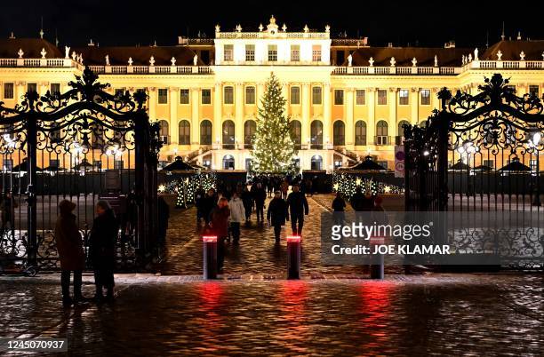 Schoenbrunn palace in Vienna, Austria, is illuminated as customers visit a Christmas market on a rainy November 24, 2022.