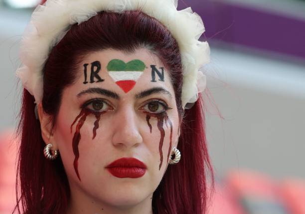 An Iran supporter with her face made up to show tears of blood under a heart in the Iranian colours, poses for photographs ahead of the Qatar 2022...