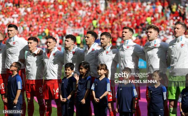 Wales's teamates sing the national anthem prior to the Qatar 2022 World Cup Group B football match between Wales and Iran at the Ahmad Bin Ali...