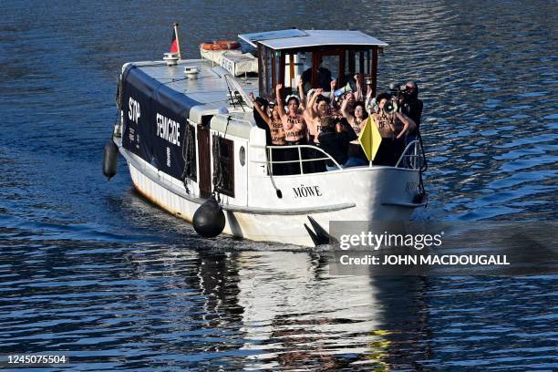 Activists of feminist activist group Femen shout slogans while standing on a boat on the Spree river during a protest action on the International Day...
