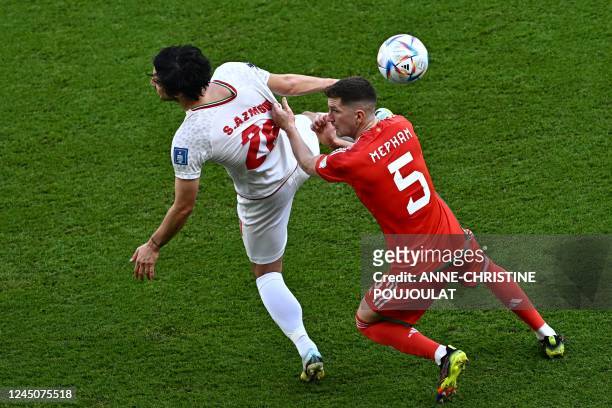 Iran's forward Sardar Azmoun fights for the ball with Wales' defender Chris Mepham during the Qatar 2022 World Cup Group B football match between...