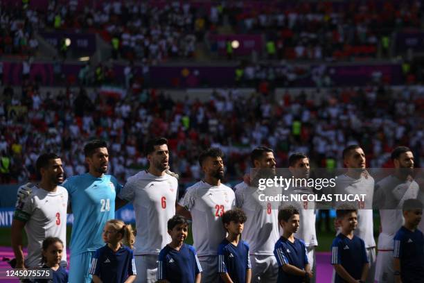 Iran's teammates sing the national anthem prior to the Qatar 2022 World Cup Group B football match between Wales and Iran at the Ahmad Bin Ali...