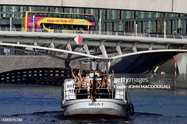 Activists of feminist activist group Femen shout slogans while standing on a boat on the Spree river during a protest action on the International Day...