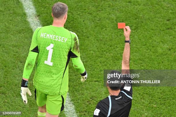 Guatemalan referee Mario Escobar shows a red card to Wales' goalkeeper Wayne Hennessey following a VR review during the Qatar 2022 World Cup Group B...