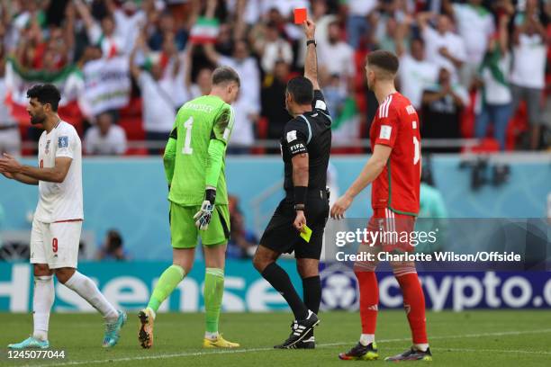 Referee Mario Escobar changes his decision after viewing the VAR monitor and issues a red card to Wales goalkeeper Wayne Hennessey during the FIFA...