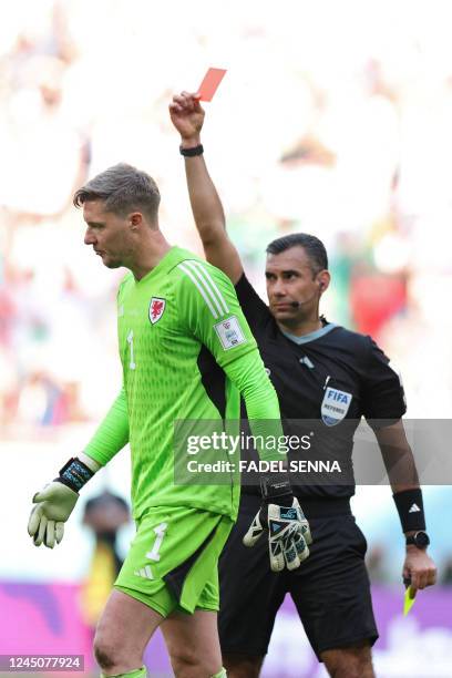 Guatemalan referee Mario Escobar shows a red card to Wales' goalkeeper Wayne Hennessey during the Qatar 2022 World Cup Group B football match between...
