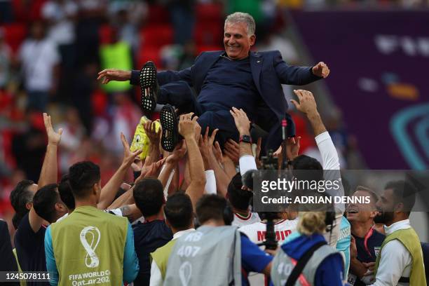 Iran's players celebrate their victory with Portuguese coach Carlos Queiroz during the Qatar 2022 World Cup Group B football match between Wales and...