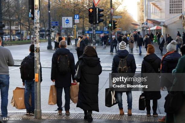 Shoppers wait at a traffic signal during Black Friday sales in Berlin, Germany, on Friday, Nov. 25, 2022. The recent wave of relief across the retail...