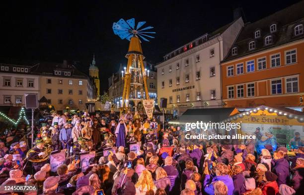 November 2022, Saxony, Annaberg-Buchholz: Numerous visitors watch the "Living Market Pyramid" being pushed into place, which traditionally opens the...