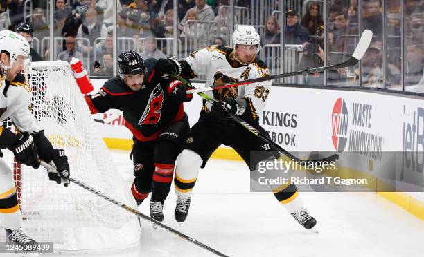 Brad Marchand of the Boston Bruins battles Seth Jarvis of the Carolina Hurricanes during the second period at the TD Garden on November 25, 2022 in...