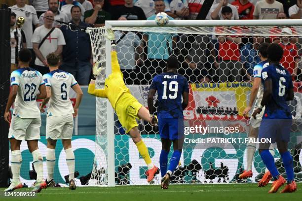 England's goalkeeper Jordan Pickford dives to save a shot during the Qatar 2022 World Cup Group B football match between England and USA at the...